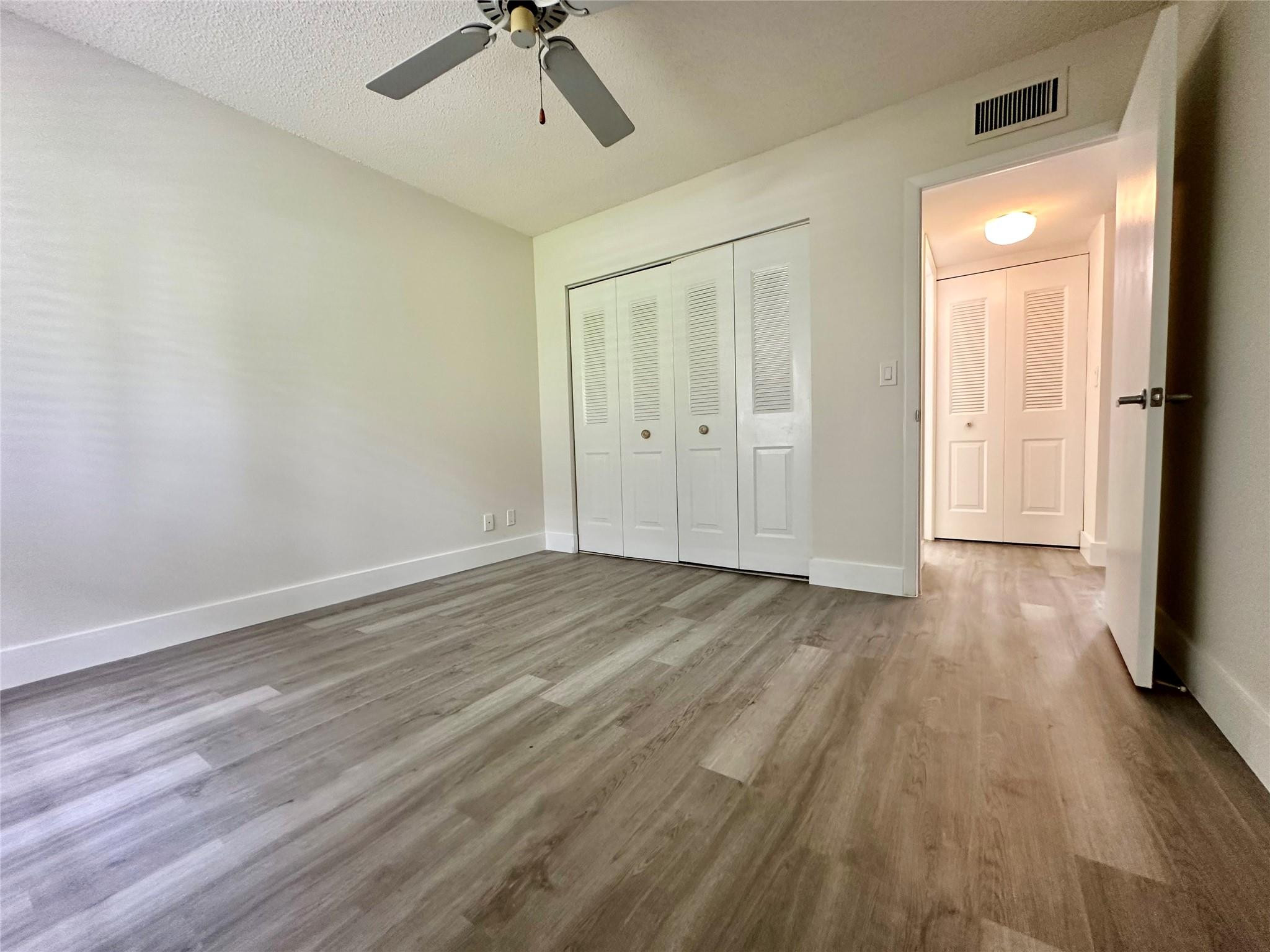 159 Northwest 70th Street, Unit 517 Boca Raton, FL 33487 - Photo 24 of 30 an empty room with wooden floor and windows