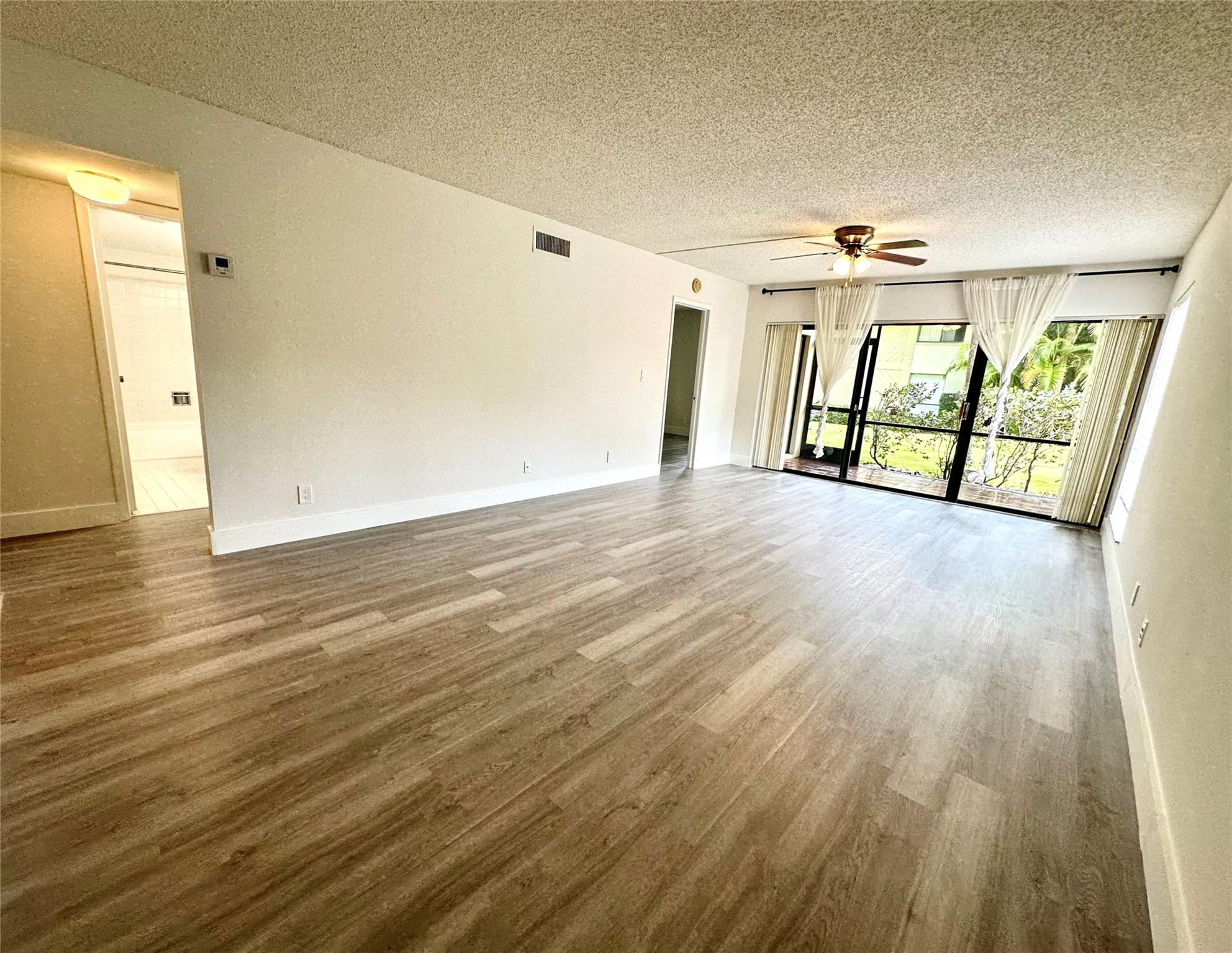 159 Northwest 70th Street, Unit 517 Boca Raton, FL 33487 - Photo 8 of 30 a view of an empty room with wooden floor and a window