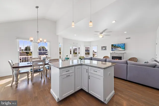 a living room with furniture kitchen view and a flat screen tv