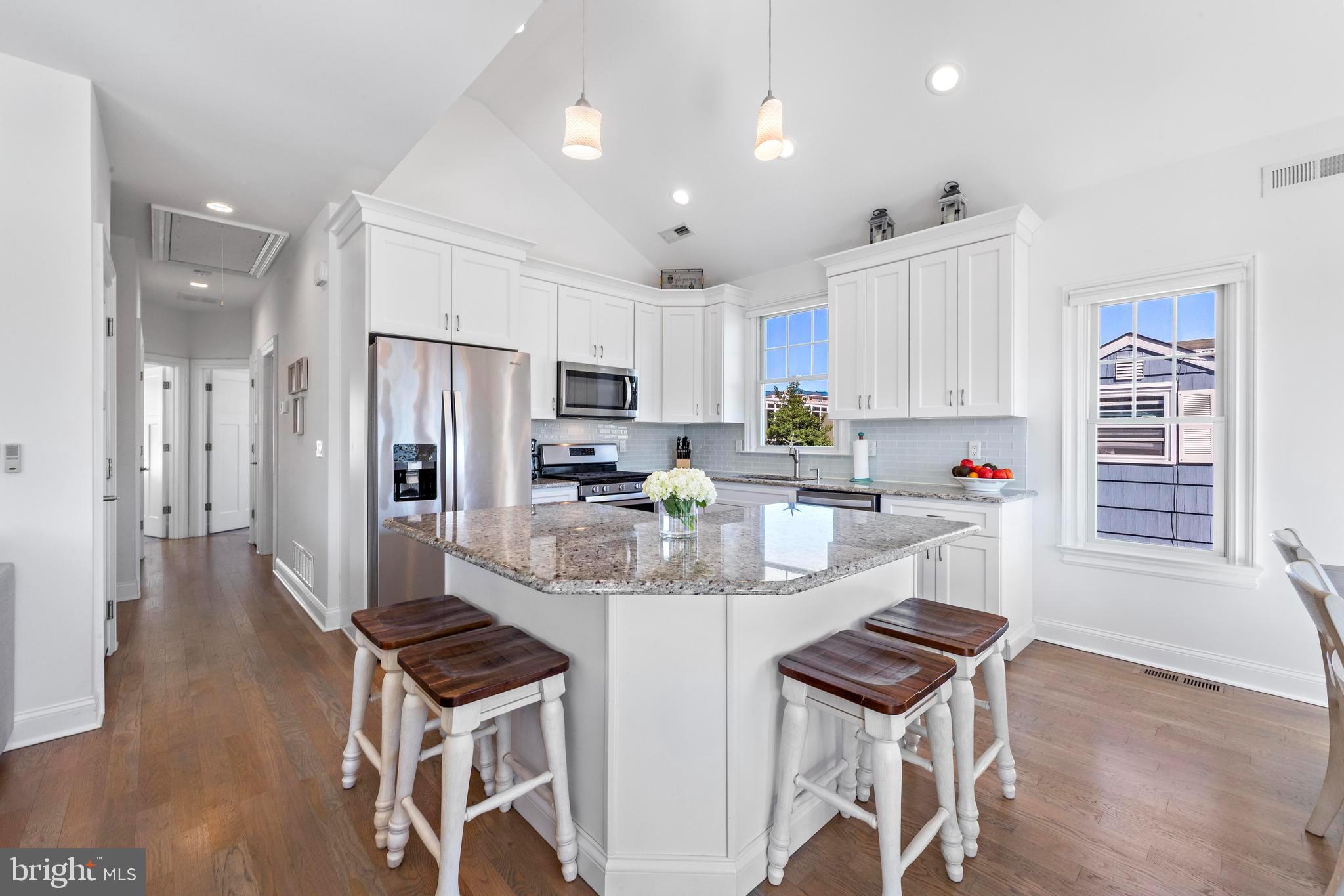 369 West 10th Street Ship Bottom, NJ 08008 - Photo 20 of 110 a kitchen with stainless steel appliances a refrigerator a stove a sink dishwasher and a dining table with wooden floor