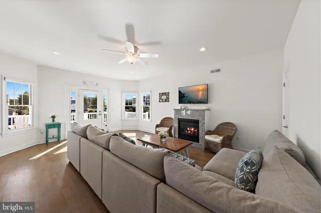 a view of a dining room and livingroom with furniture wooden floor a chandelier
