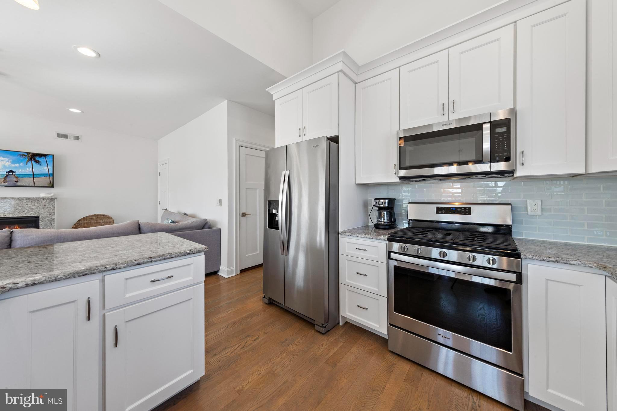 369 West 10th Street Ship Bottom, NJ 08008 - Photo 37 of 110 a kitchen with stainless steel appliances granite countertop a stove a refrigerator and a microwave