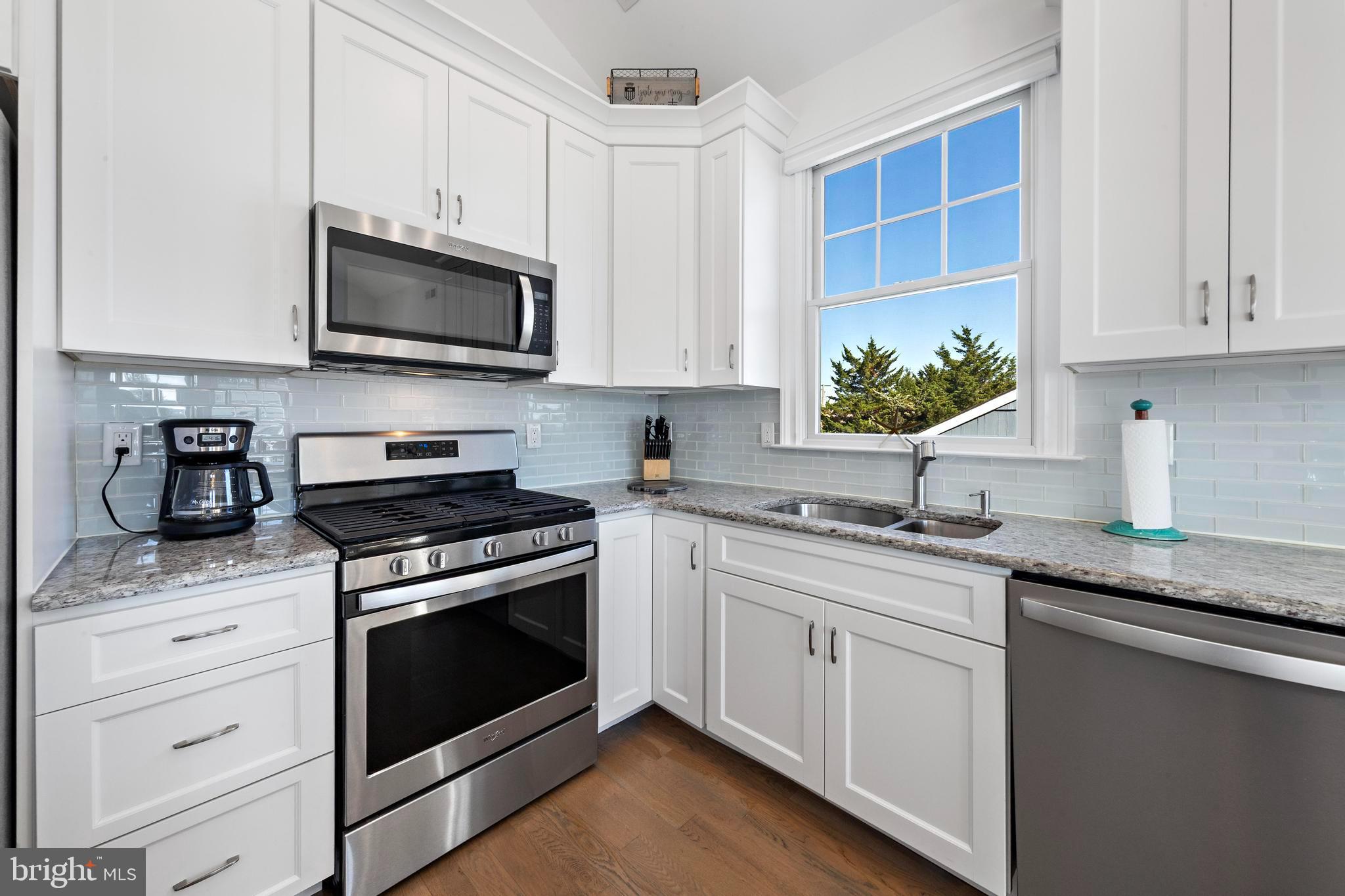 369 West 10th Street Ship Bottom, NJ 08008 - Photo 38 of 110 a kitchen with granite countertop white cabinets stainless steel appliances and a sink