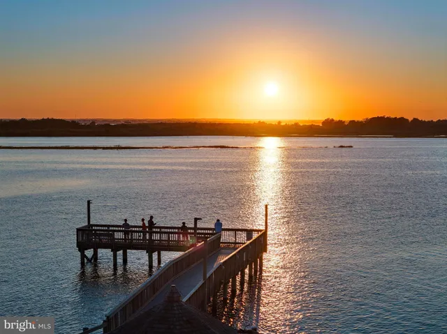 a kitchen with stainless steel appliances a refrigerator a stove a sink dishwasher and a dining table with wooden floor