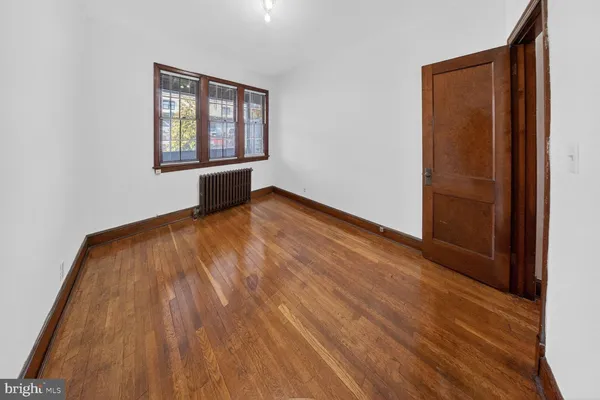 an empty room with wooden floor and a window