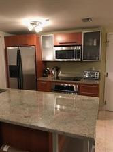 185 Southwest 7th Street, Unit 3507 Miami, FL 33130 - Photo 6 of 19 a kitchen with stainless steel appliances granite countertop a refrigerator and a stove