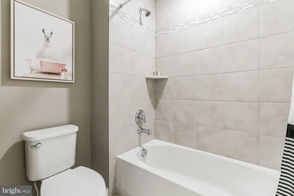 a white toilet sitting next to a bath tub