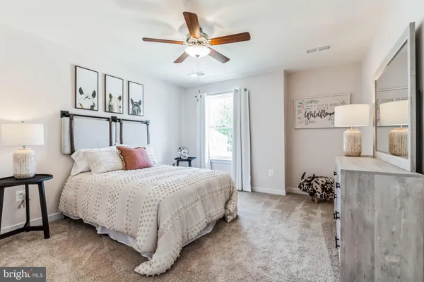 a bedroom with a bed chandelier and a window