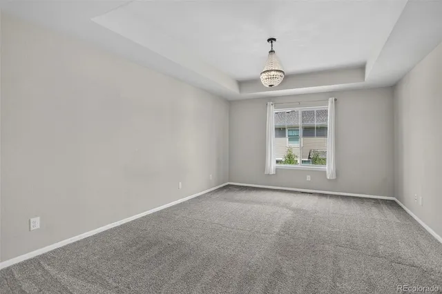 an empty room with windows and ceiling fan