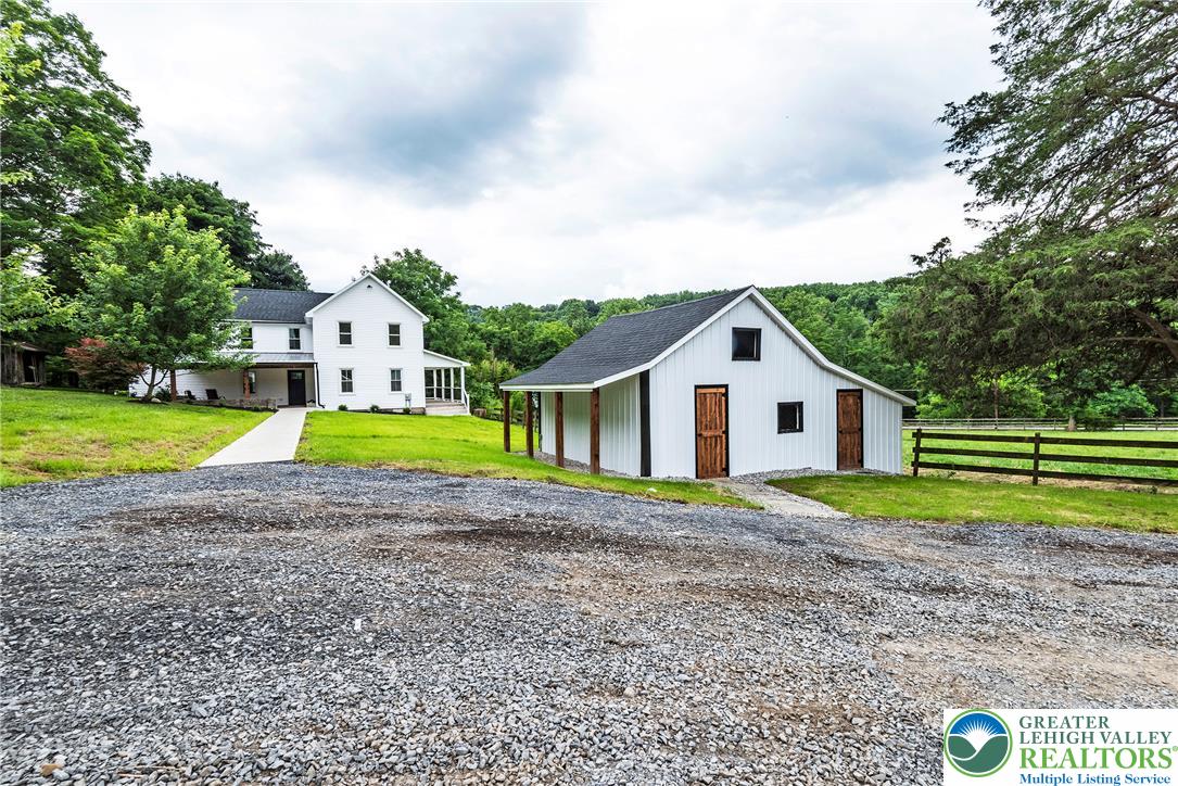 72 Allegheny Road Mount Bethel, PA 18343 - Photo 52 of 72 A classic white farmhouse and a charming barn are nestled in a verdant, open landscape.