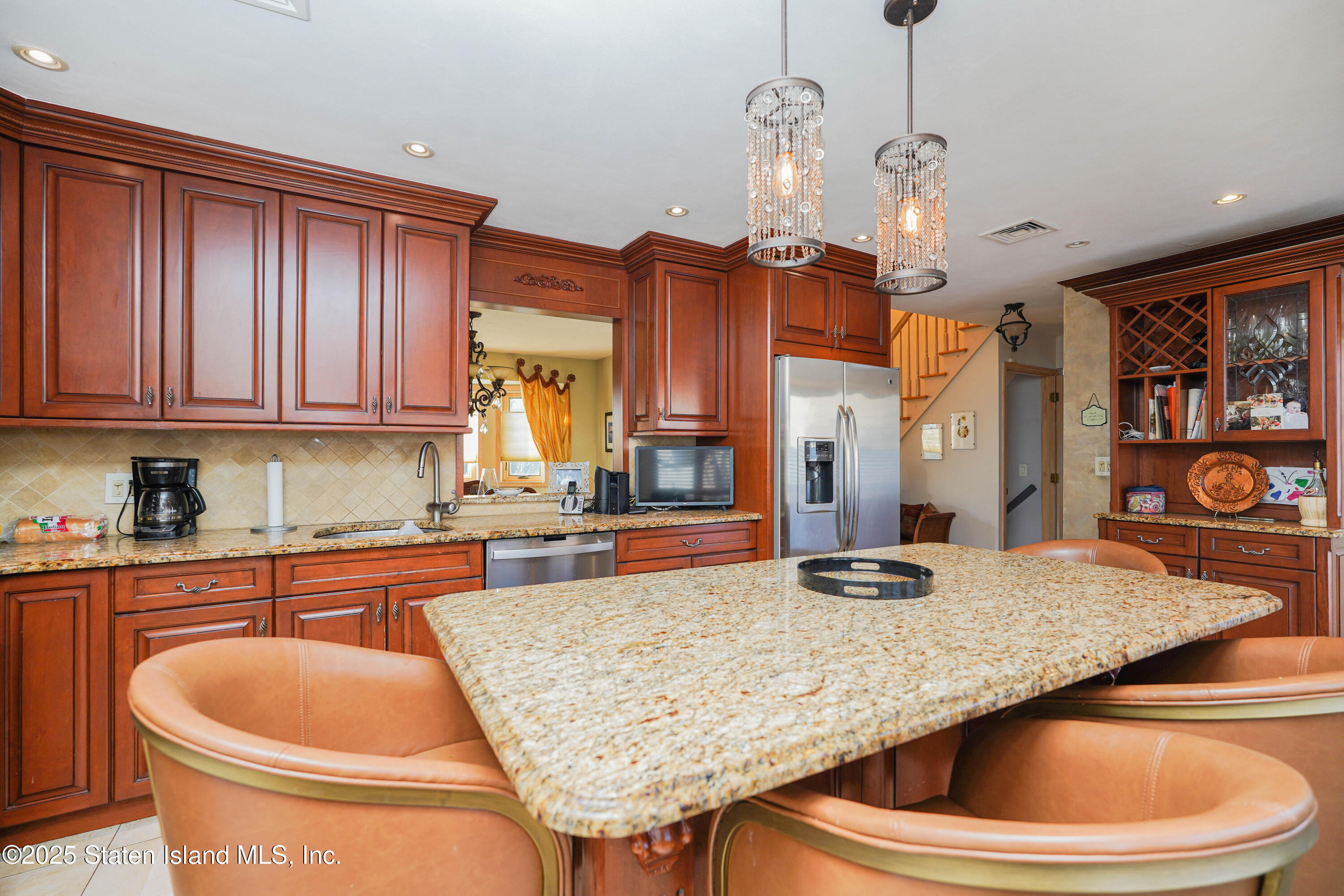 1527 Woodrow Road Staten Island, NY 10309 - Photo 14 of 37 a kitchen with stainless steel appliances granite countertop a sink a microwave and wooden cabinets
