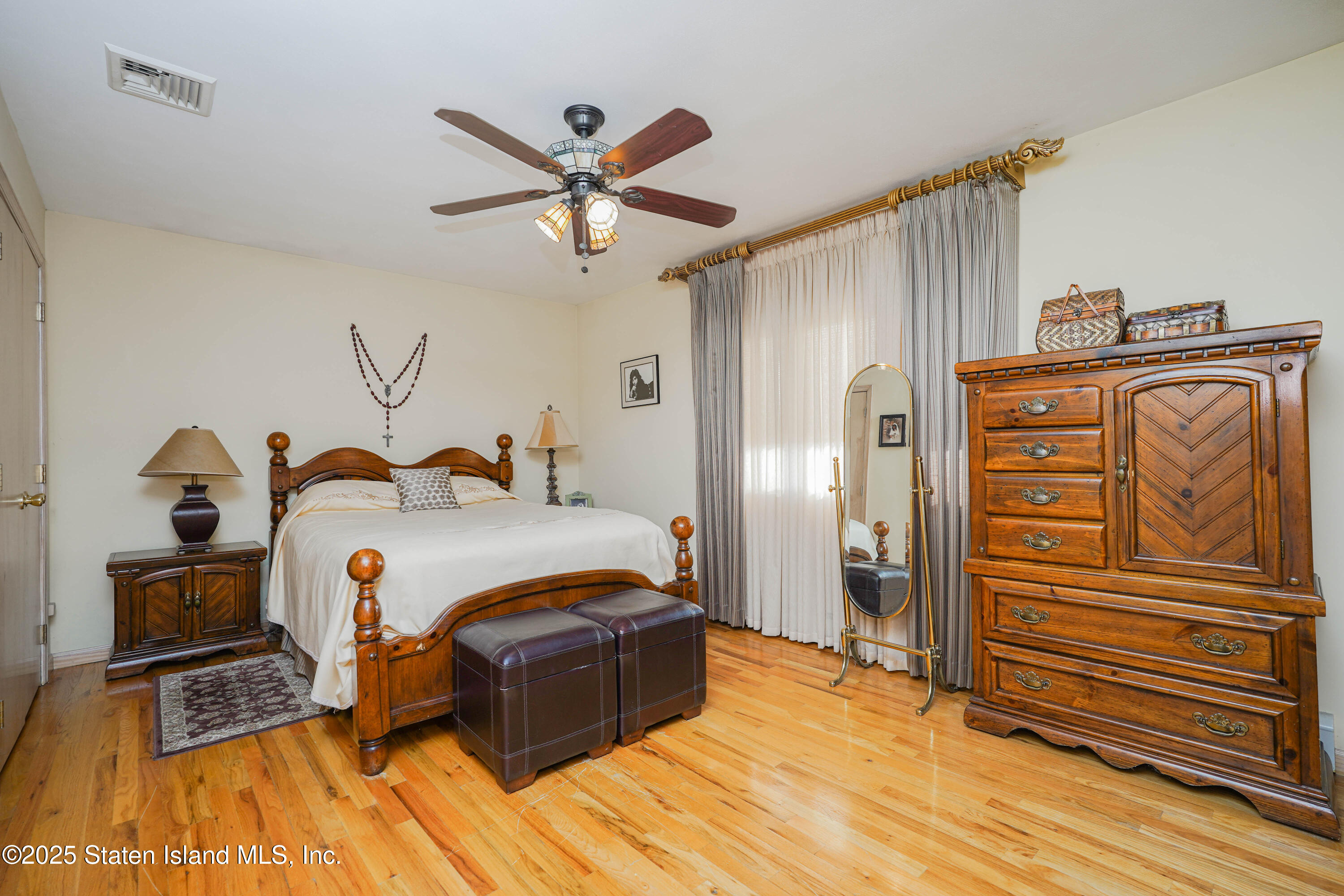 1527 Woodrow Road Staten Island, NY 10309 - Photo 15 of 37 a bedroom with a bed and a chandelier