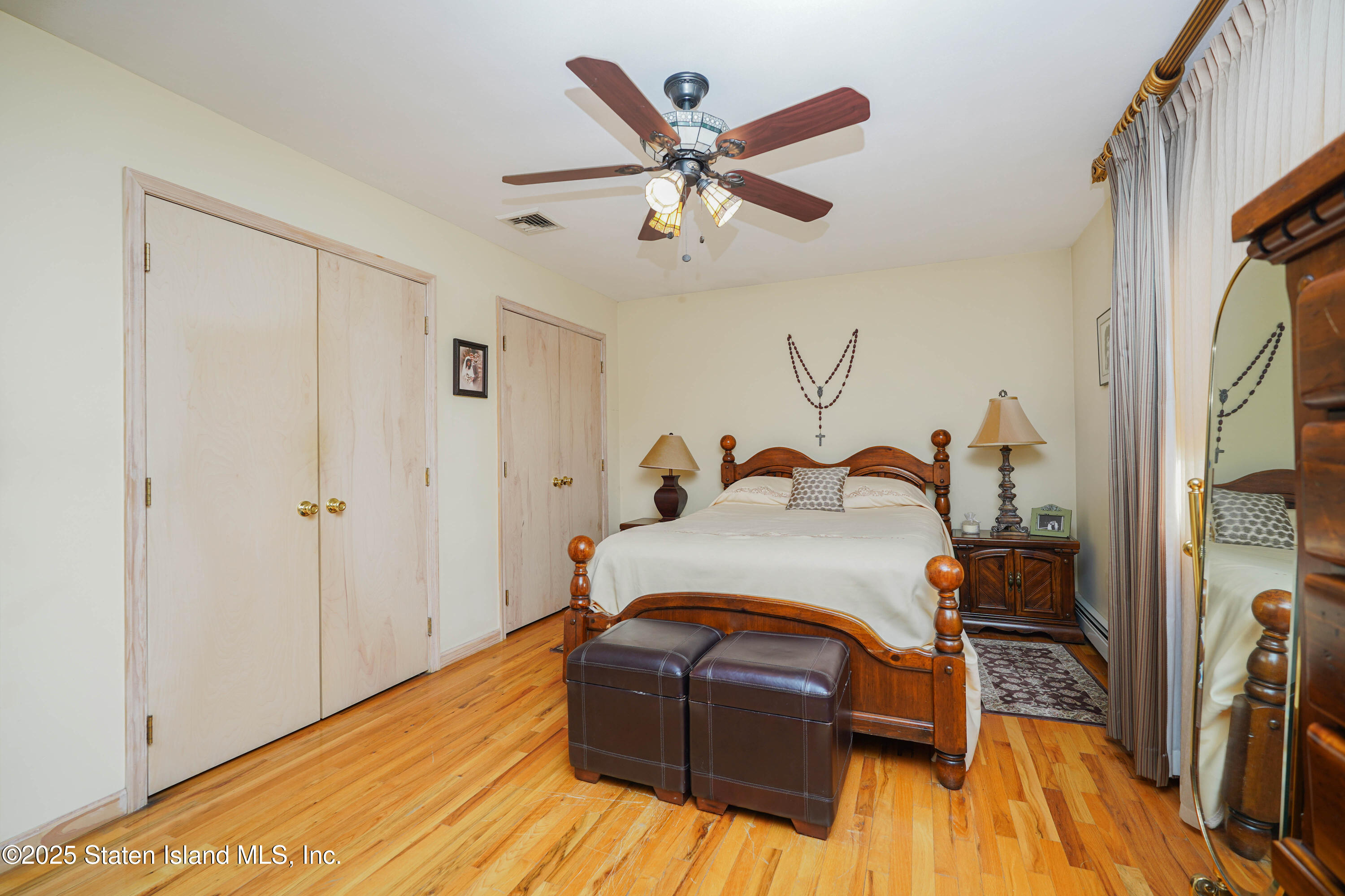 1527 Woodrow Road Staten Island, NY 10309 - Photo 16 of 37 a bedroom with a bed and wooden floor
