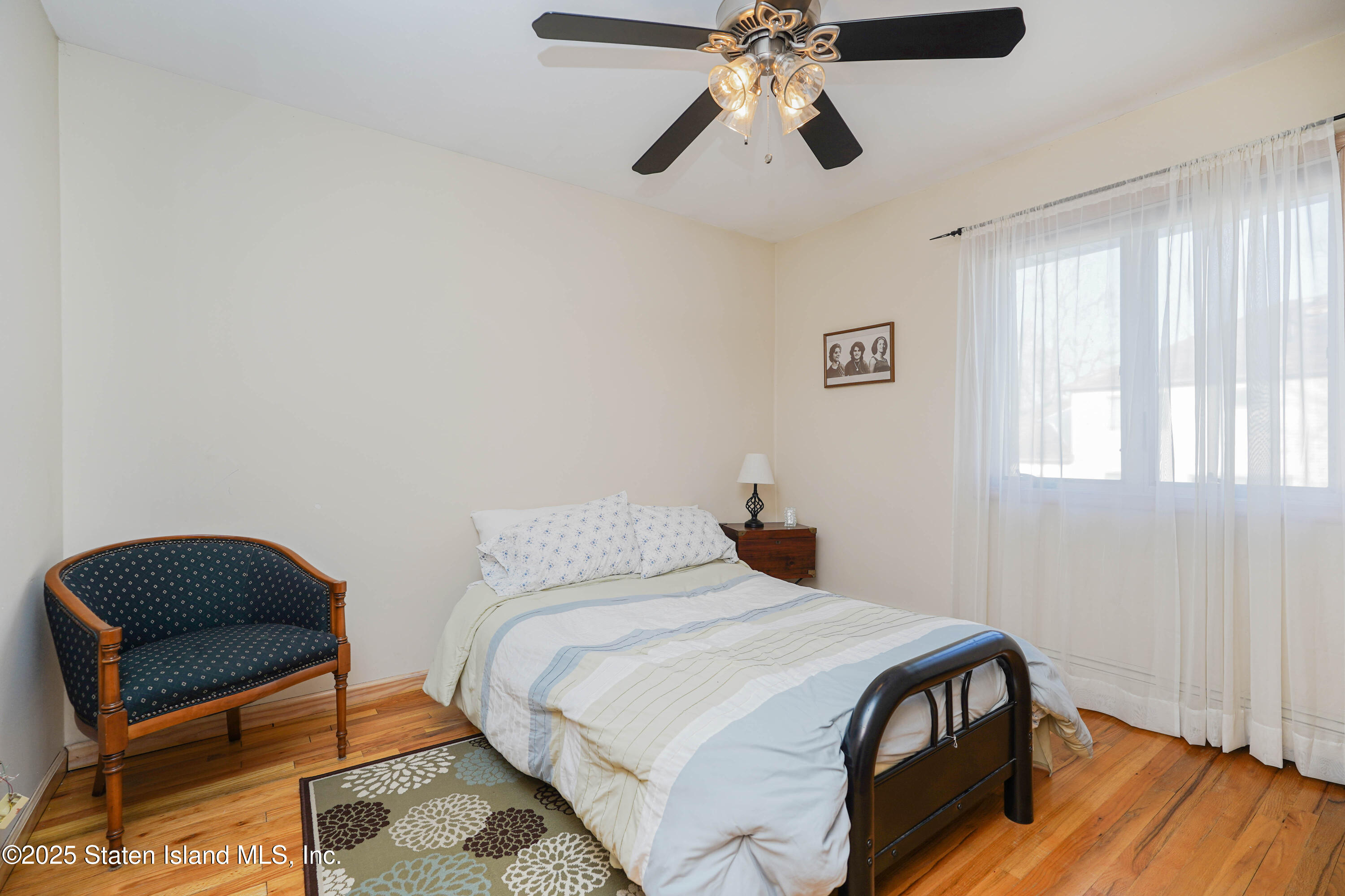 1527 Woodrow Road Staten Island, NY 10309 - Photo 20 of 37 a bedroom with a bed and a chandelier