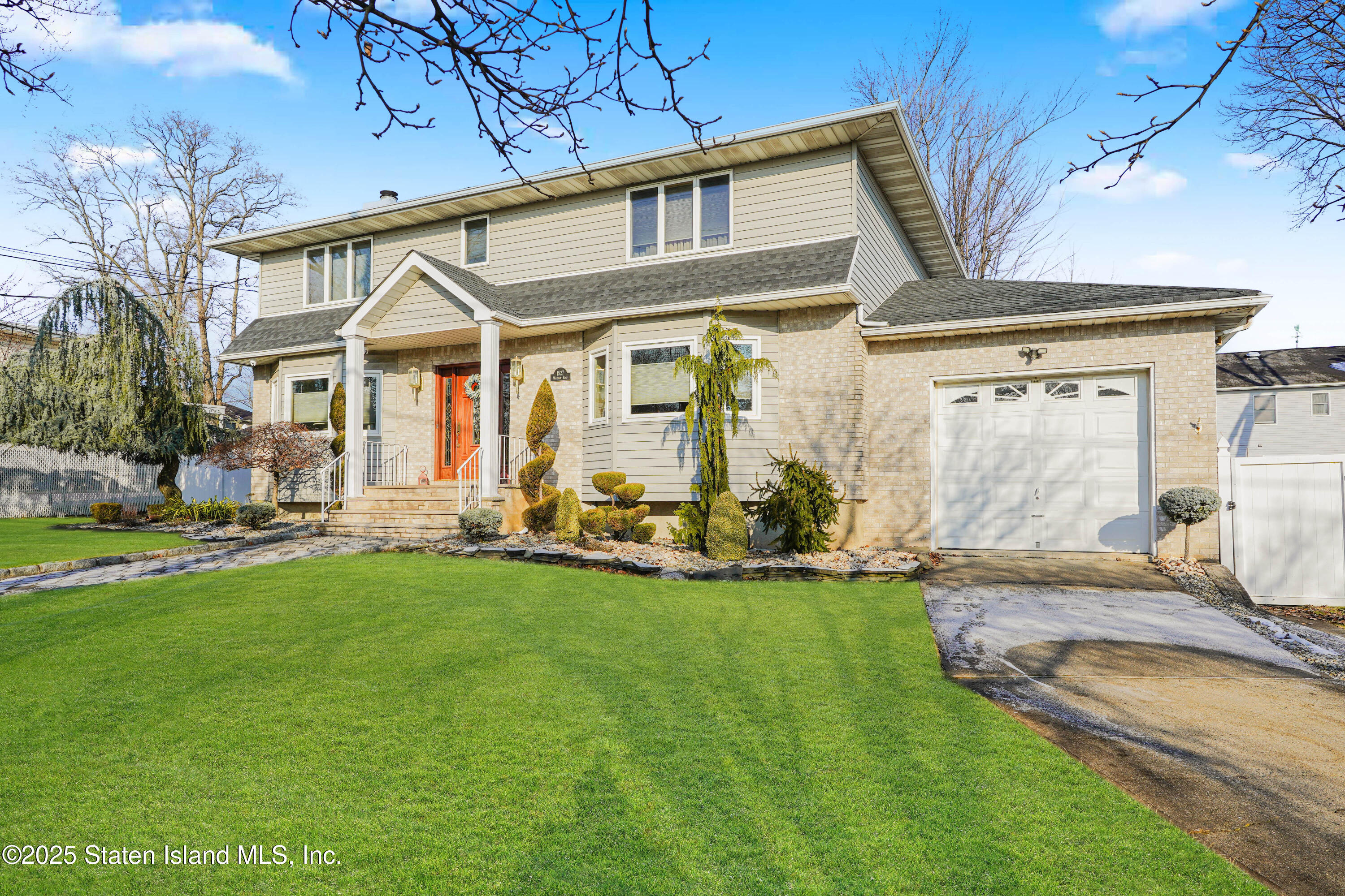 1527 Woodrow Road Staten Island, NY 10309 - Photo 2 of 37 a front view of a house with a garden and patio