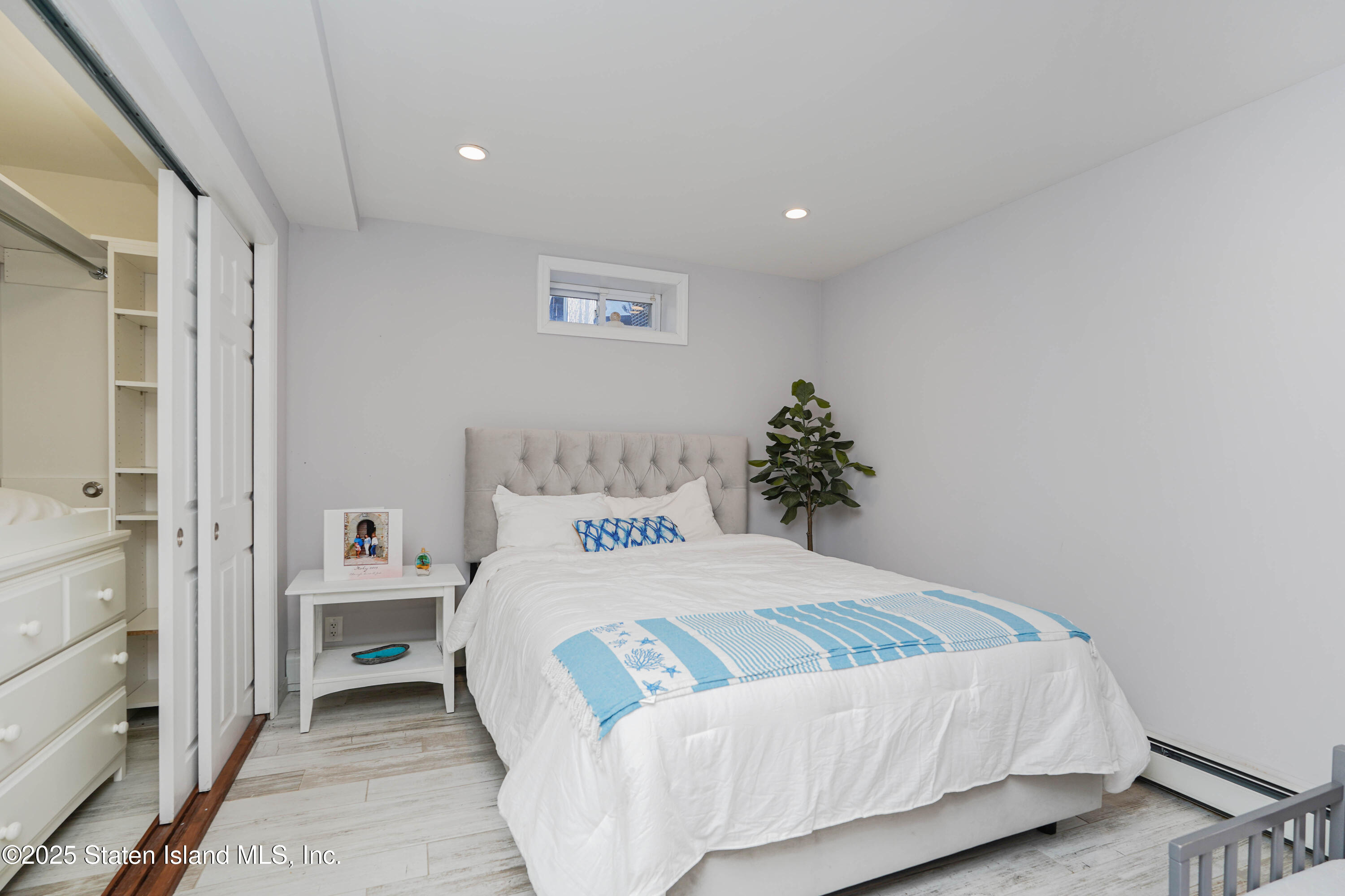 1527 Woodrow Road Staten Island, NY 10309 - Photo 22 of 37 a bedroom with a bed and a potted plant