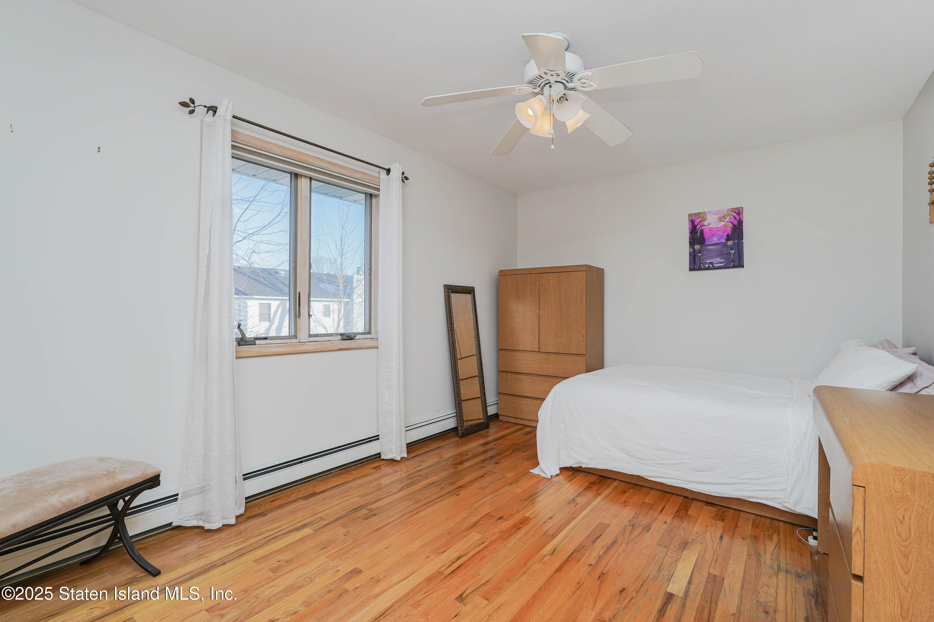 1527 Woodrow Road Staten Island, NY 10309 - Photo 24 of 37 a bedroom with a bed and a chandelier