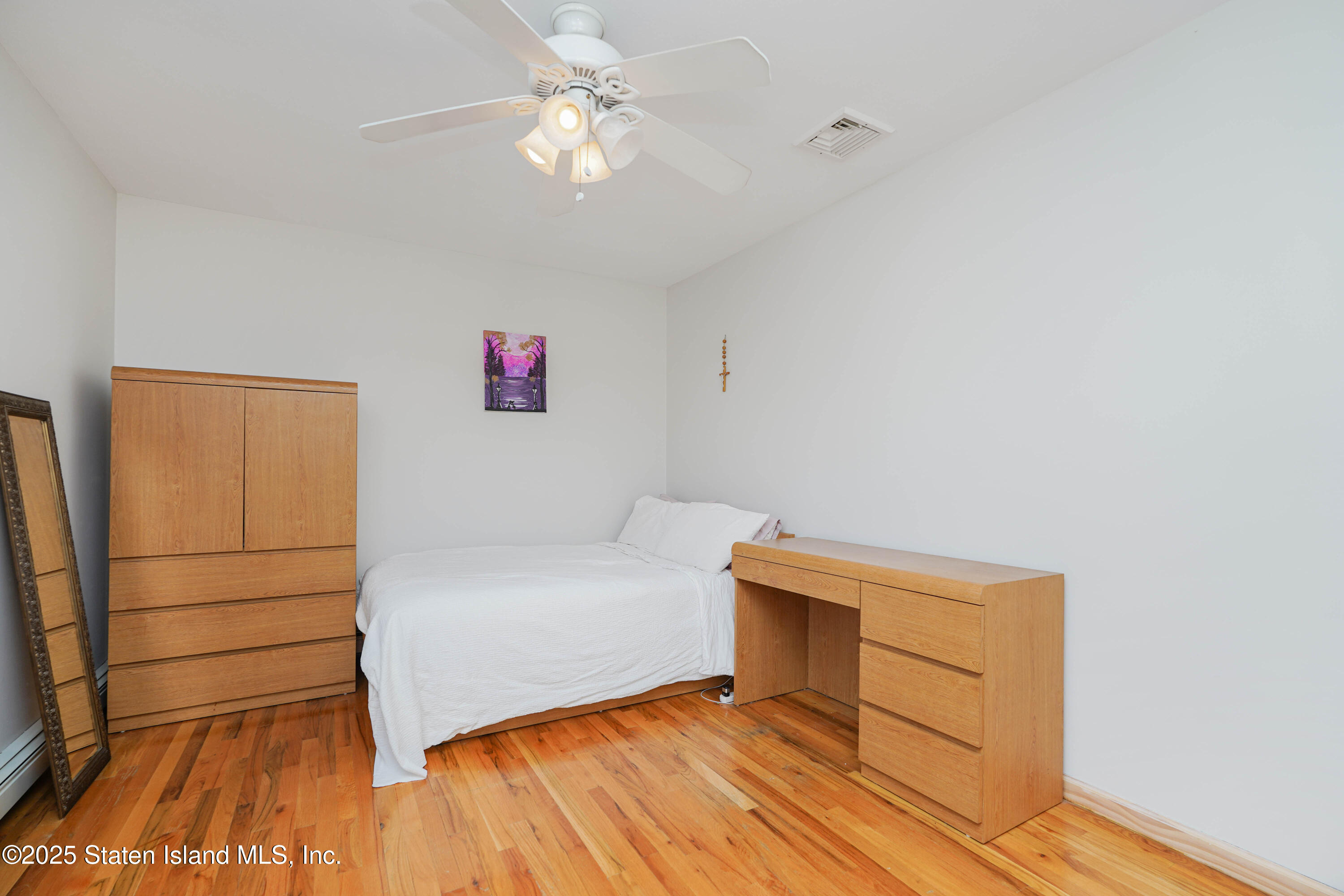 1527 Woodrow Road Staten Island, NY 10309 - Photo 25 of 37 a view of room with wooden floor and ceiling fan