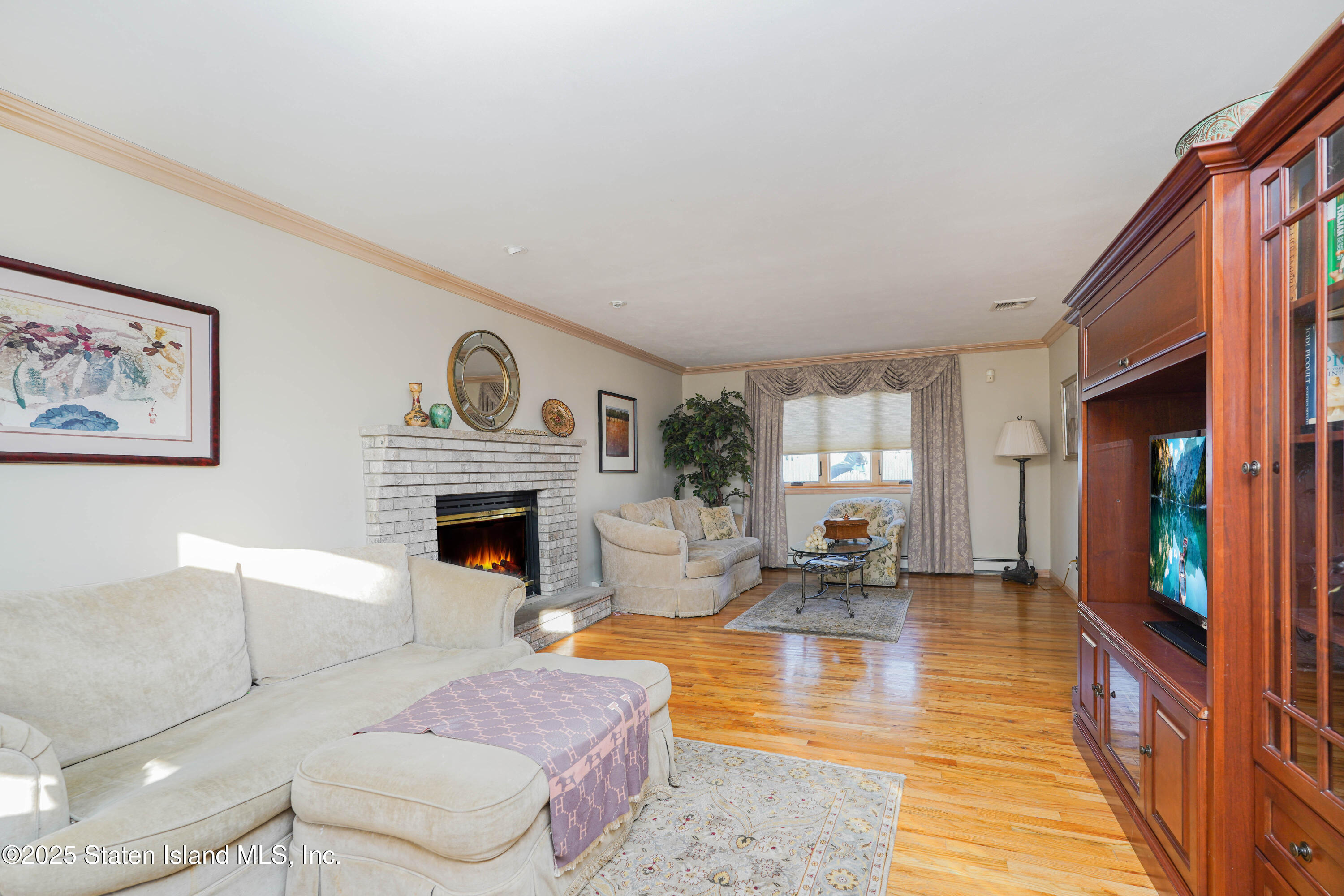 1527 Woodrow Road Staten Island, NY 10309 - Photo 7 of 37 a living room with furniture and a fireplace