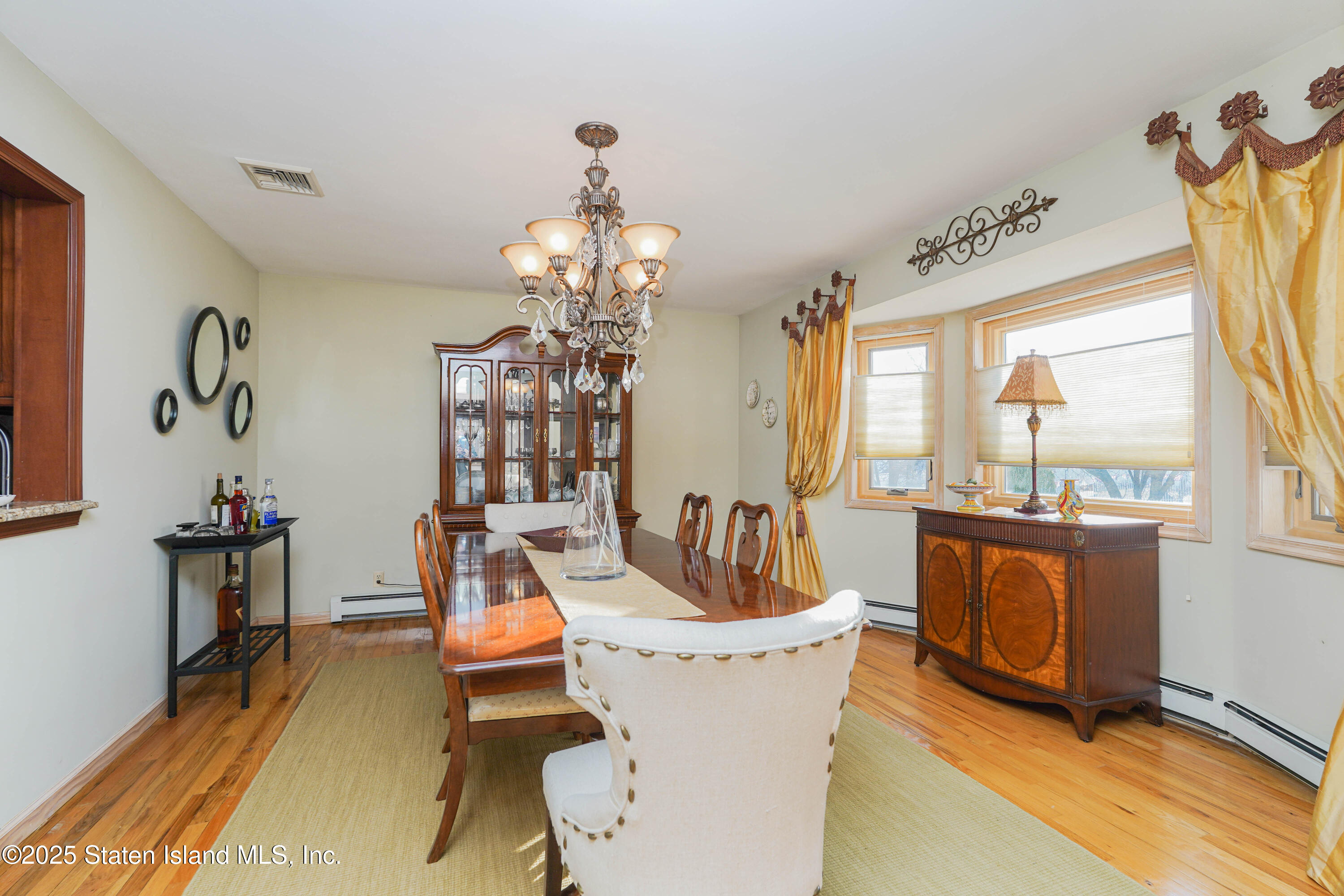 1527 Woodrow Road Staten Island, NY 10309 - Photo 8 of 37 a living room with furniture a chandelier and a dining table