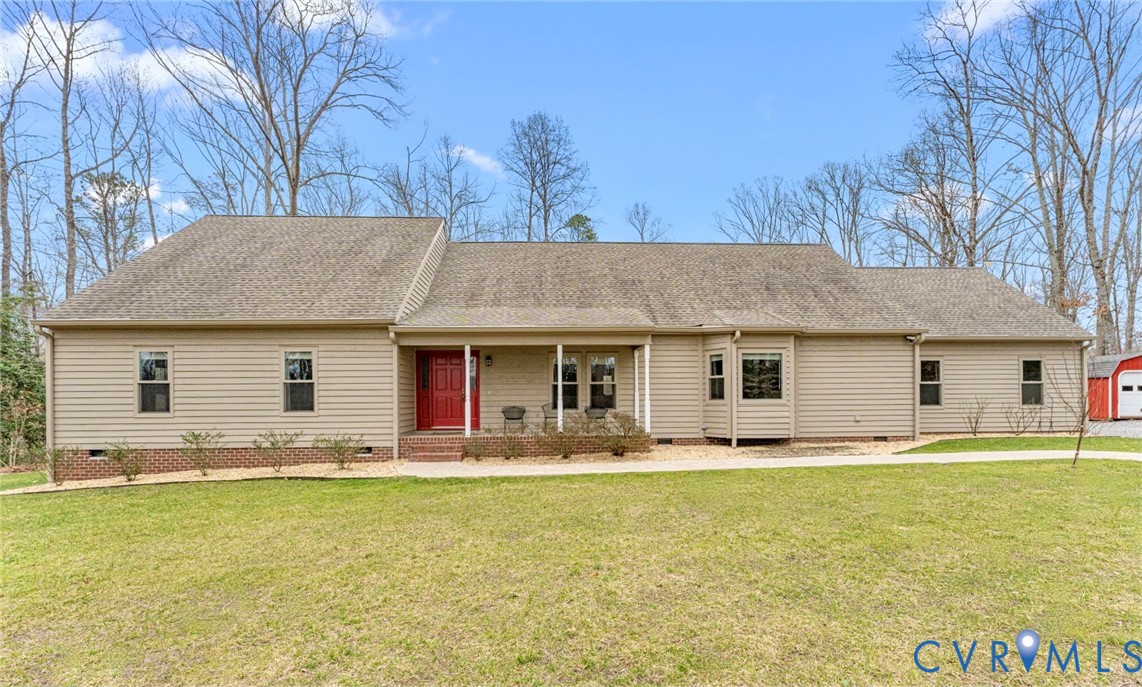 a front view of house with yard and trees in the background