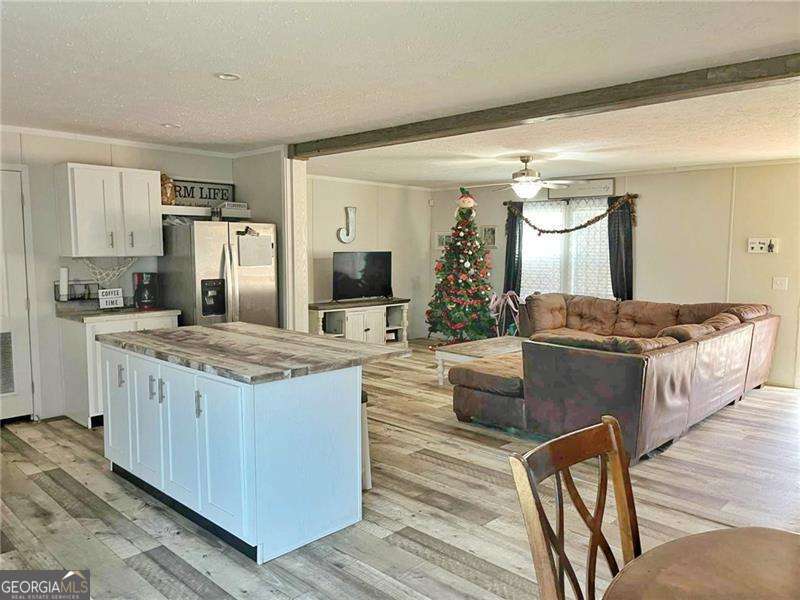 349 Dublin Circle Rome, GA 30161 - Photo 4 of 11 a kitchen with kitchen island granite countertop wooden cabinets and a refrigerator