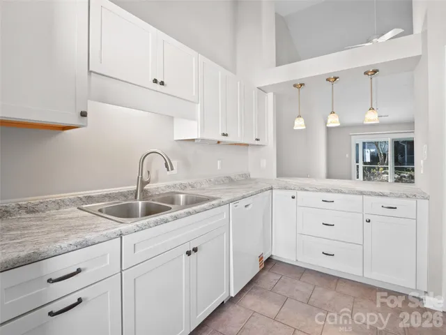 a kitchen with white cabinets and sink