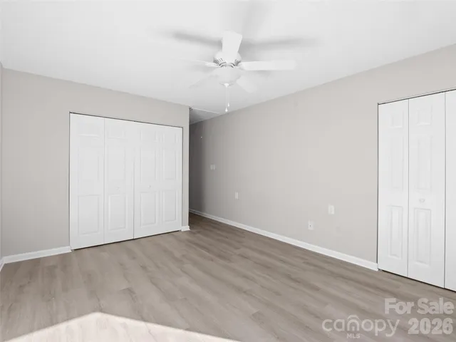 an empty room with a ceiling fan and wooden floor