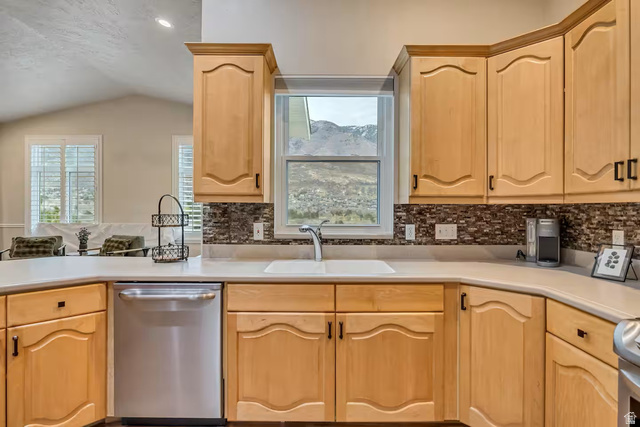 11789 Nicklaus Road Sandy, UT 84092 - Photo 11 of 58 Kitchen with dishwasher, light wood finish cabinets, light countertops, backsplash, and lofted ceiling