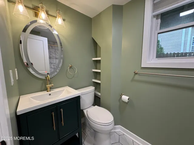 a bathroom with a toilet sink and mirror