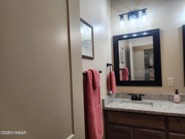 a bathroom with a granite countertop sink and a mirror