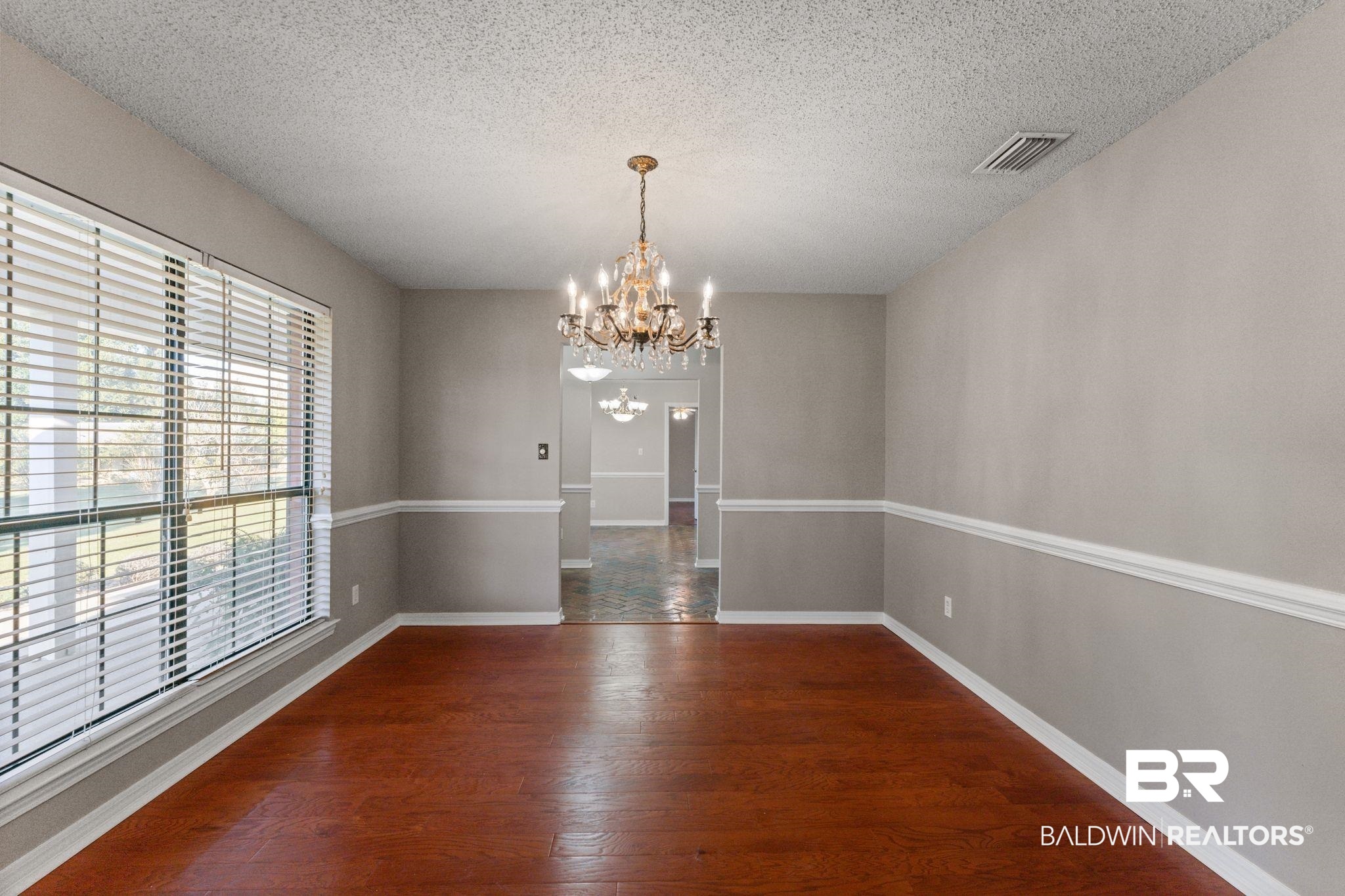 888 Mobile Cut-Off Road St. Stephens, AL 36569 - Photo 12 of 54 Unfurnished dining area with a textured ceiling, dark wood-type flooring, and a chandelier