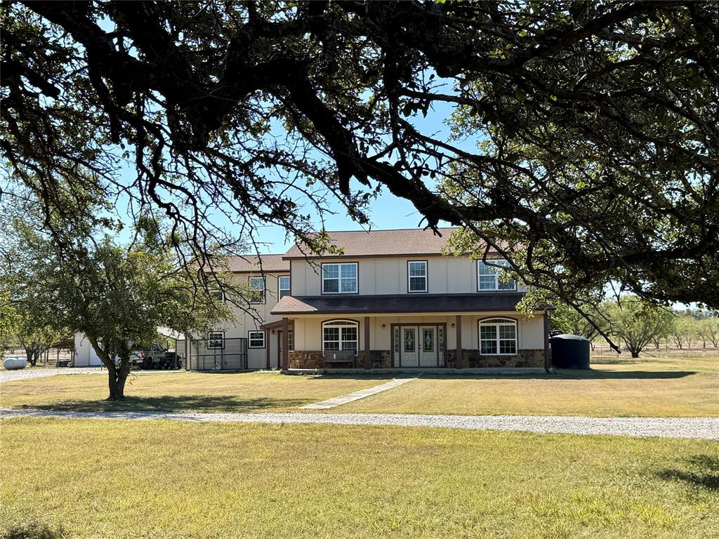 a front view of a house with a large trees