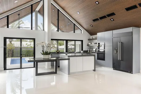 a kitchen with stainless steel appliances kitchen island granite countertop a refrigerator and cabinets