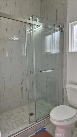 a bathroom with a toilet and a shower