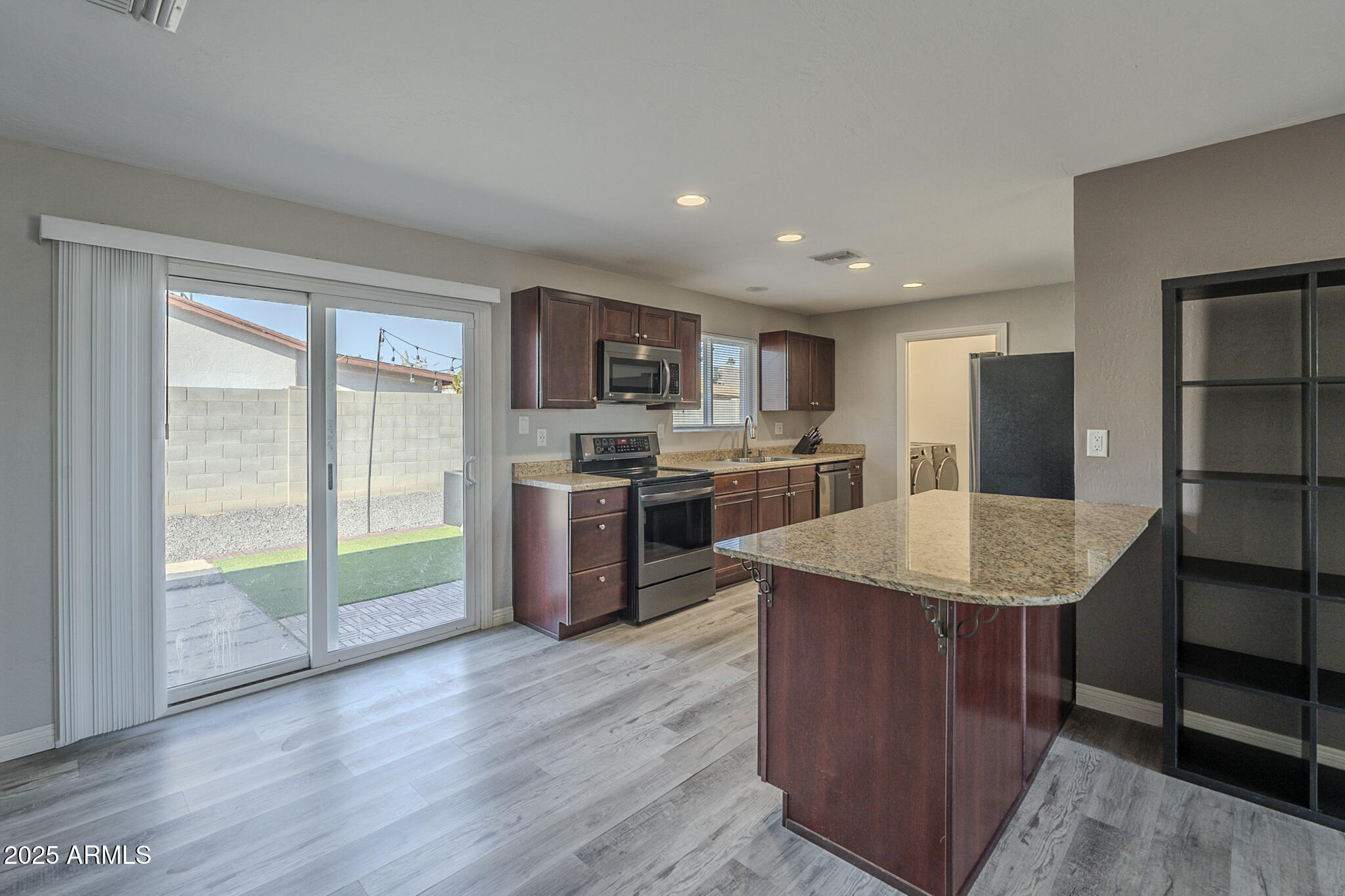 2914 East Cactus Road Phoenix, AZ 85032 - Photo 11 of 49 a kitchen with stainless steel appliances granite countertop a stove a refrigerator a sink a oven with wooden cabinets and floor