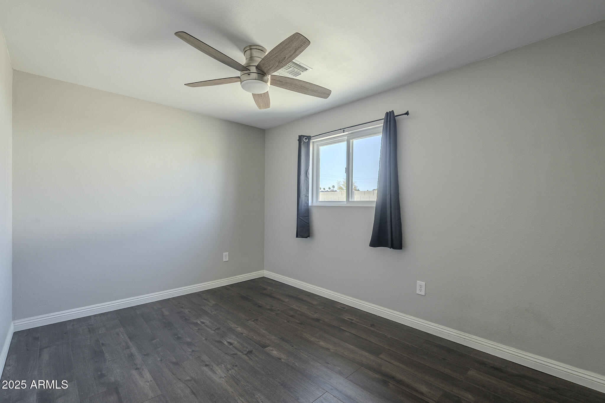 2914 East Cactus Road Phoenix, AZ 85032 - Photo 21 of 49 an empty room with wooden floor fan and windows