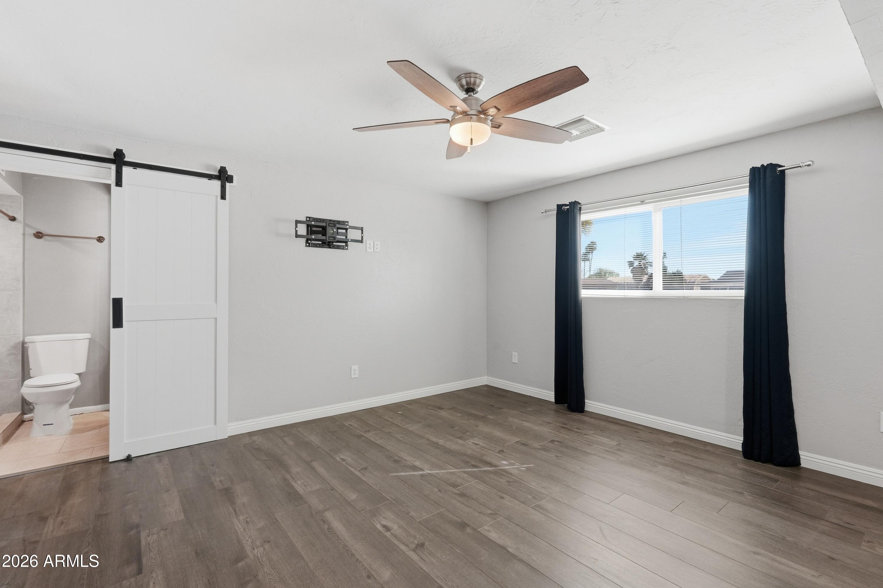 2914 East Cactus Road Phoenix, AZ 85032 - Photo 23 of 40 a view of a hallway with wooden floor and a ceiling fan