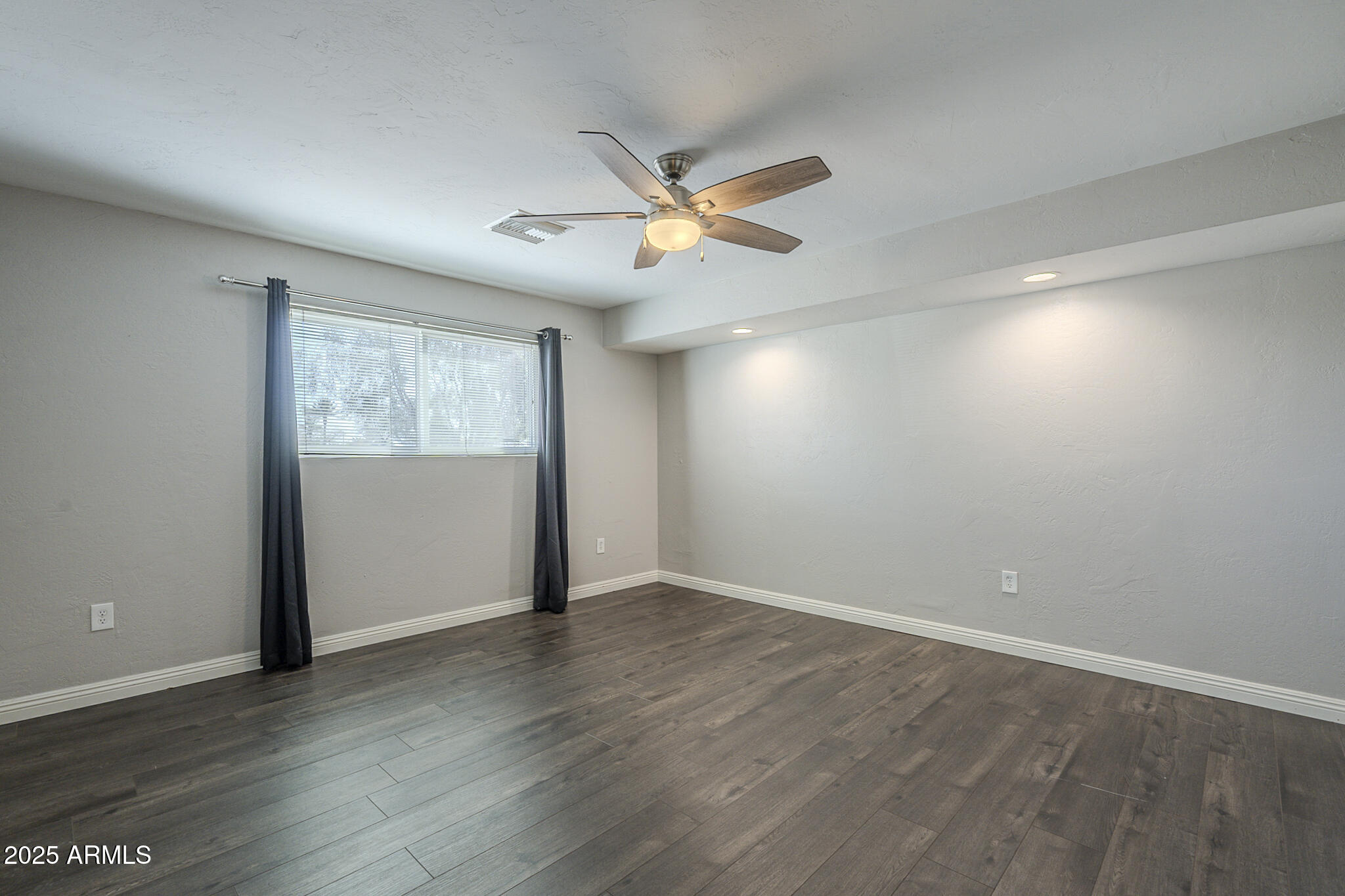 2914 East Cactus Road Phoenix, AZ 85032 - Photo 25 of 49 an empty room with wooden floor ceiling fan and windows