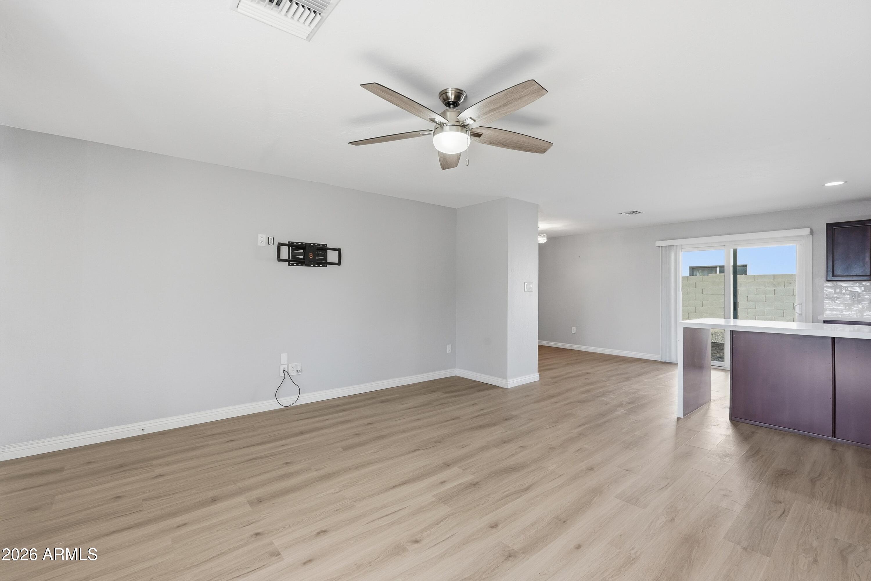 2914 East Cactus Road Phoenix, AZ 85032 - Photo 3 of 40 a view of an empty room with window and wooden floor
