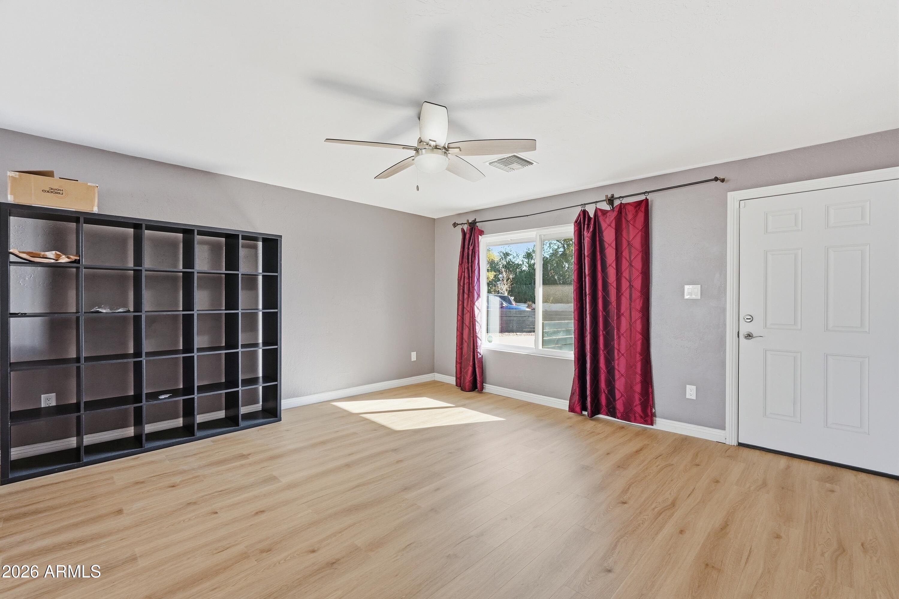 2914 East Cactus Road Phoenix, AZ 85032 - Photo 5 of 40 a view of a room with a large window and wooden floor