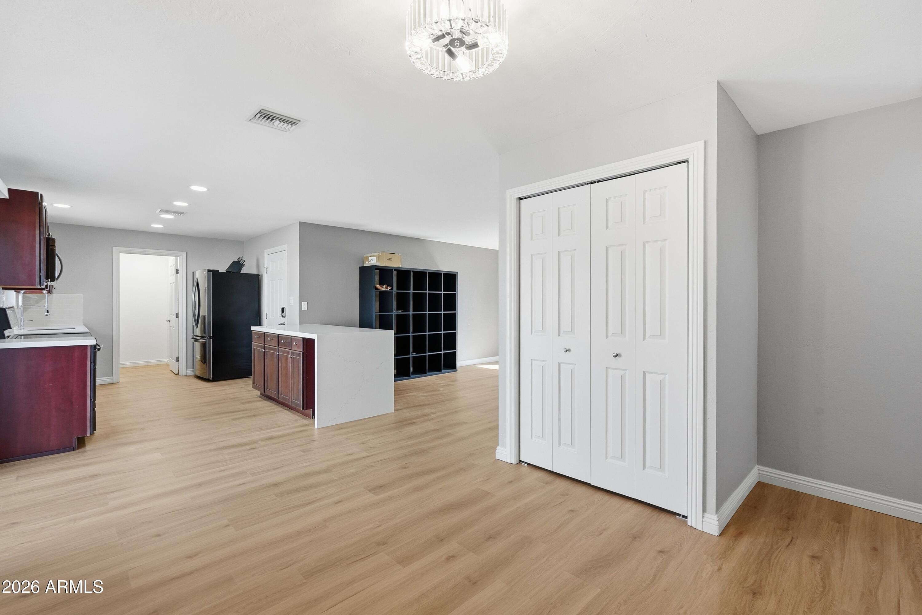 2914 East Cactus Road Phoenix, AZ 85032 - Photo 8 of 40 a large room with wooden floor and a kitchen space with a sink