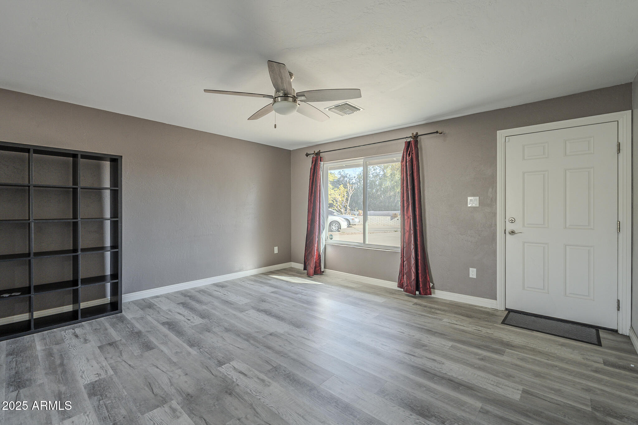 2914 East Cactus Road Phoenix, AZ 85032 - Photo 10 of 49 an empty room with wooden floor closet and windows
