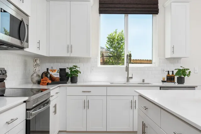 a kitchen with stainless steel appliances white cabinets and a sink