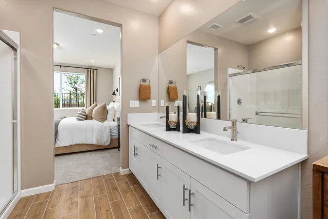 a en suite bathroom with a double vanity sink and mirror
