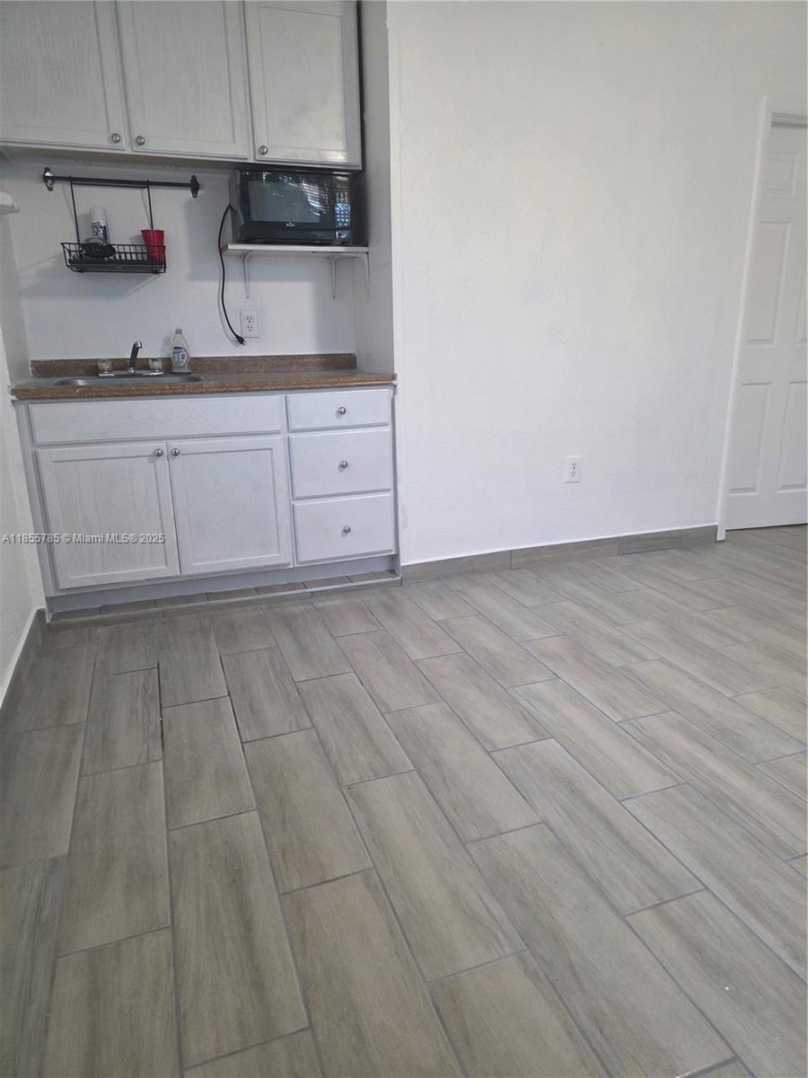 359 West 12th Street, Unit 2 Hialeah, FL 33010 - Photo 12 of 20 a kitchen with granite countertop a sink and cabinets