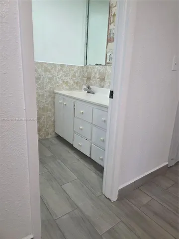 a bathroom with a granite countertop sink and a mirror