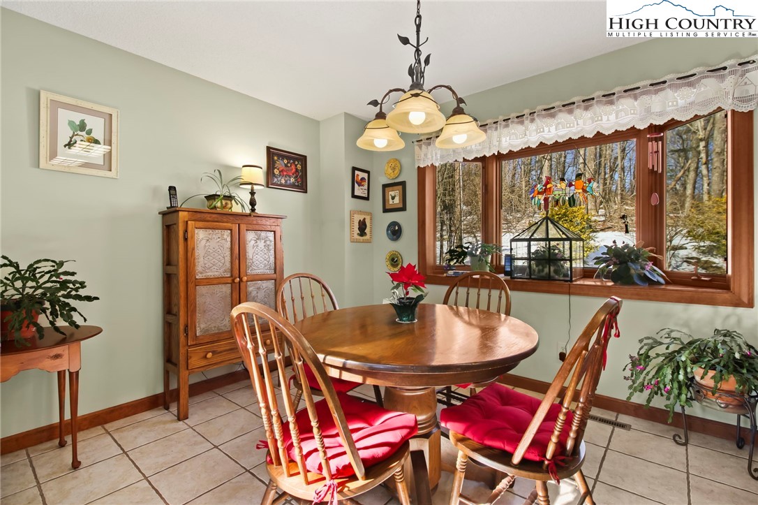 454 Huckleberry Trail Boone, NC 28607 - Photo 11 of 36 a dining room with furniture a large window and chandelier