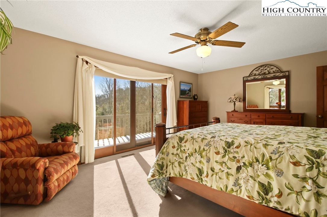 454 Huckleberry Trail Boone, NC 28607 - Photo 14 of 36 a bed room with a bed and a chandelier