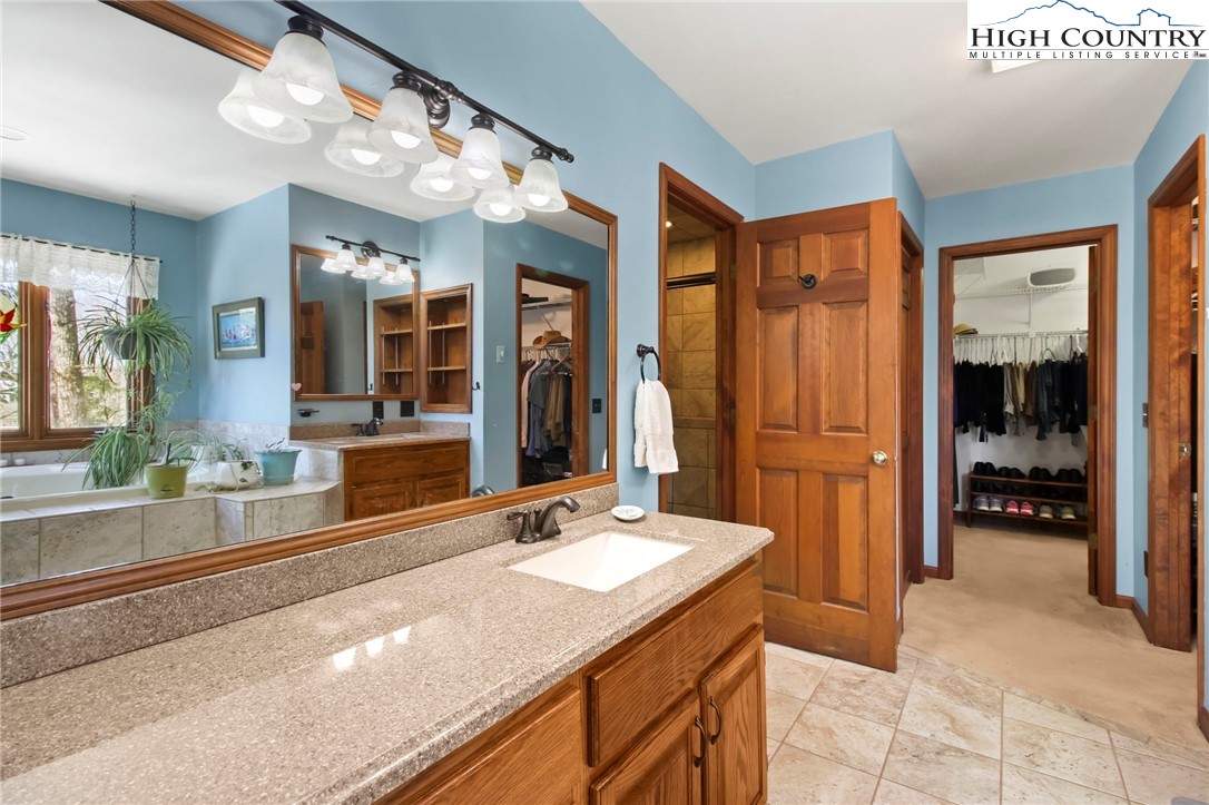 454 Huckleberry Trail Boone, NC 28607 - Photo 16 of 36 a spacious bathroom with a sink and a large mirror